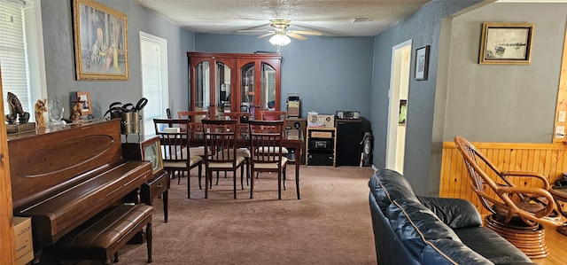 dining space featuring a textured ceiling, carpet floors, ceiling fan, and a wealth of natural light