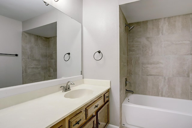 bathroom featuring tiled shower / bath and vanity