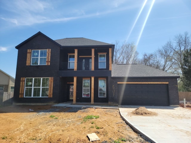 view of front of home featuring concrete driveway, a balcony, an attached garage, and brick siding