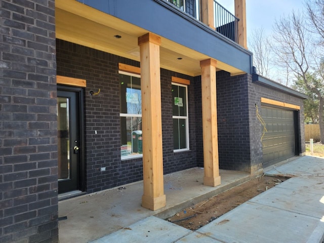 doorway to property with brick siding and a balcony