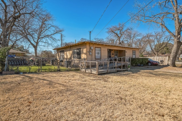 rear view of house with a yard and a deck