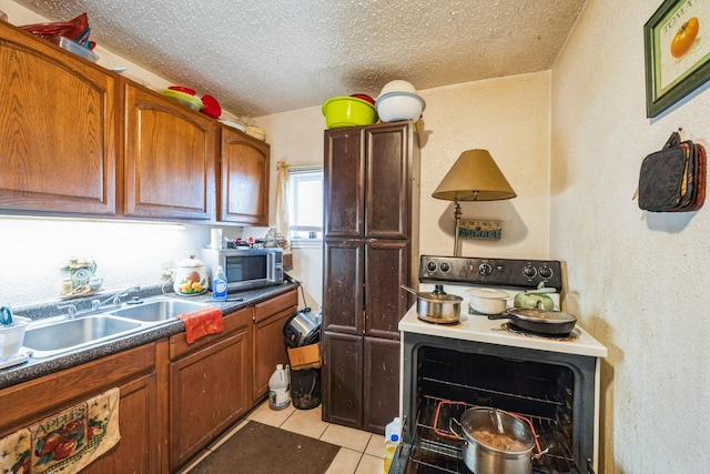 kitchen with electric stove, sink, a textured ceiling, and light tile patterned flooring