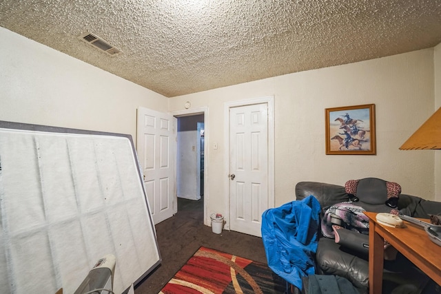 interior space with dark carpet and a textured ceiling