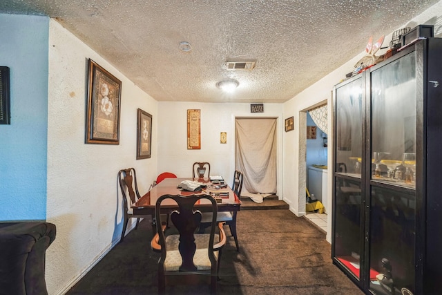 carpeted dining space with a textured ceiling