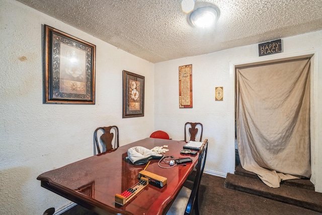 carpeted dining space with a textured ceiling