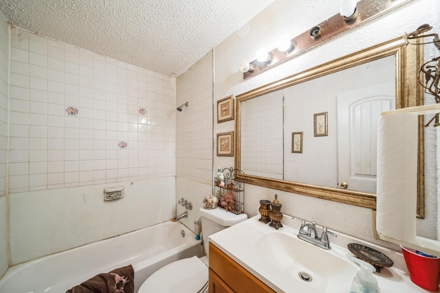 full bathroom with vanity, tiled shower / bath combo, toilet, and a textured ceiling