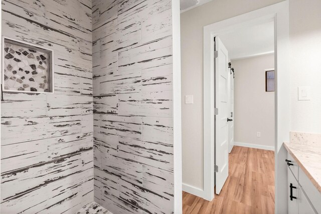 bathroom featuring hardwood / wood-style flooring, vanity, and wood walls