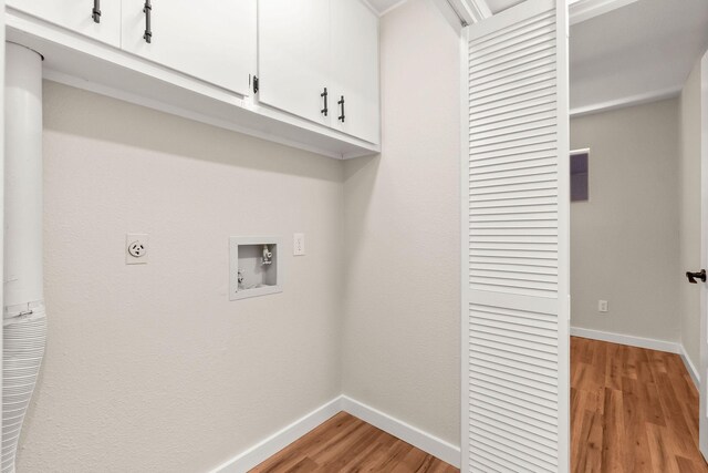 clothes washing area featuring electric dryer hookup, hookup for a washing machine, cabinets, and light wood-type flooring