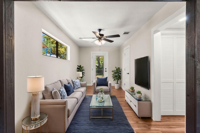 living room featuring ceiling fan and light hardwood / wood-style floors