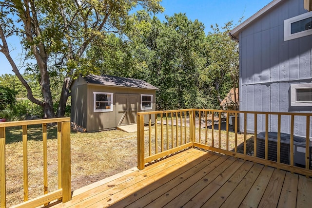 wooden deck featuring central air condition unit and a shed