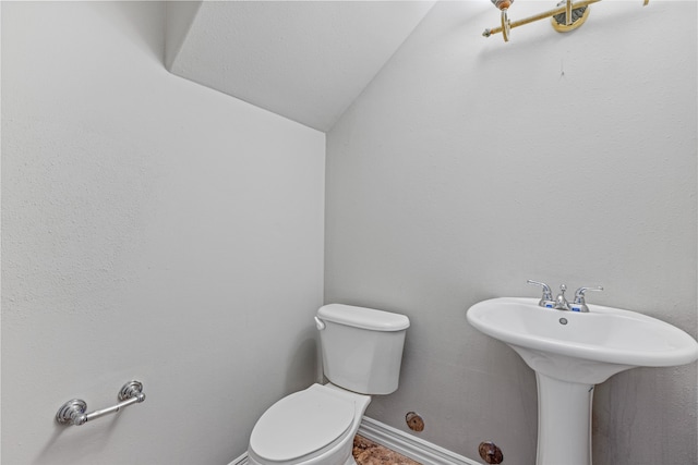 bathroom featuring toilet and vaulted ceiling