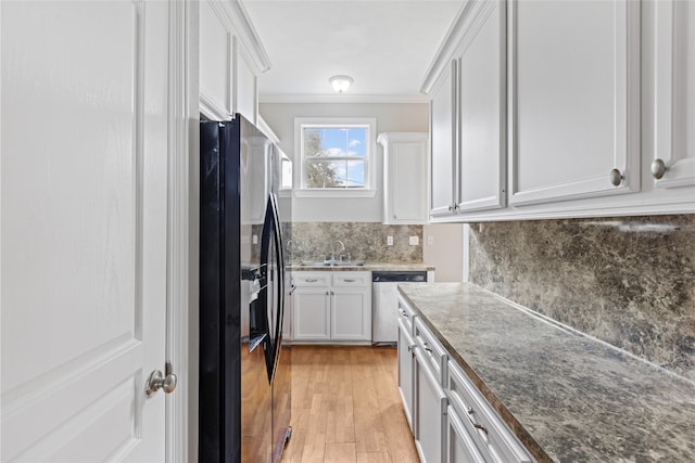 kitchen featuring white cabinetry, sink, decorative backsplash, stainless steel dishwasher, and black refrigerator with ice dispenser