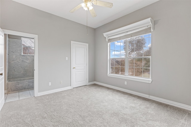 unfurnished bedroom featuring ensuite bathroom, light carpet, and ceiling fan