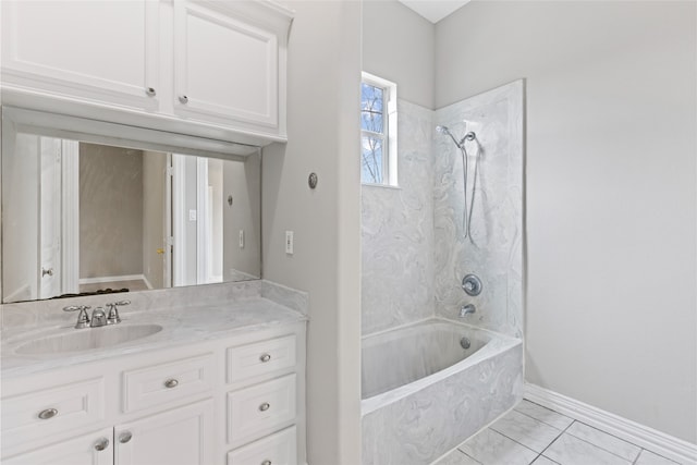 bathroom featuring tile patterned flooring, tiled shower / bath, and vanity