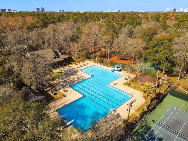 view of pool with a patio, a water slide, a diving board, and tennis court