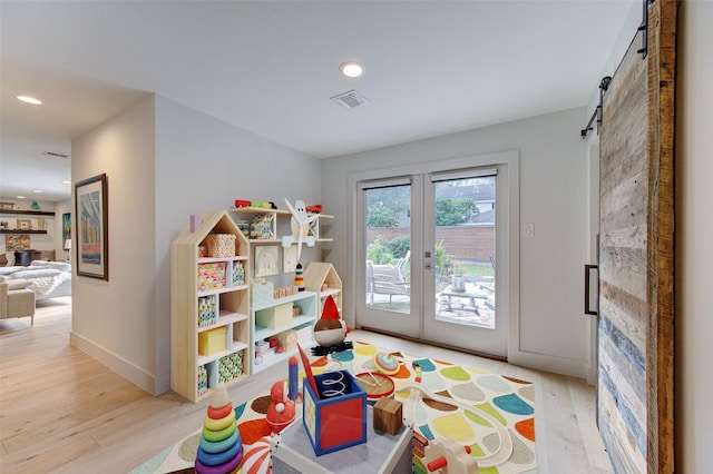 recreation room with light wood-type flooring and french doors