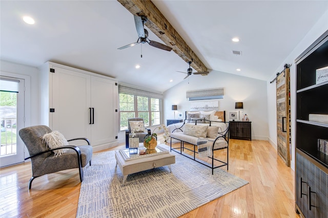 living room featuring light hardwood / wood-style floors, lofted ceiling with beams, a barn door, and ceiling fan