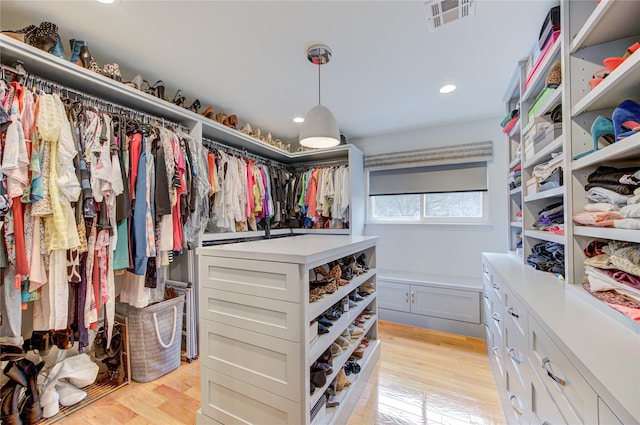 walk in closet with light hardwood / wood-style flooring