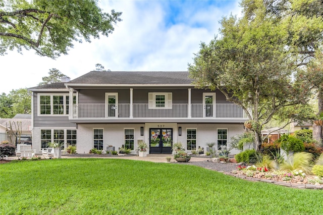 rear view of house featuring a yard, french doors, and a balcony