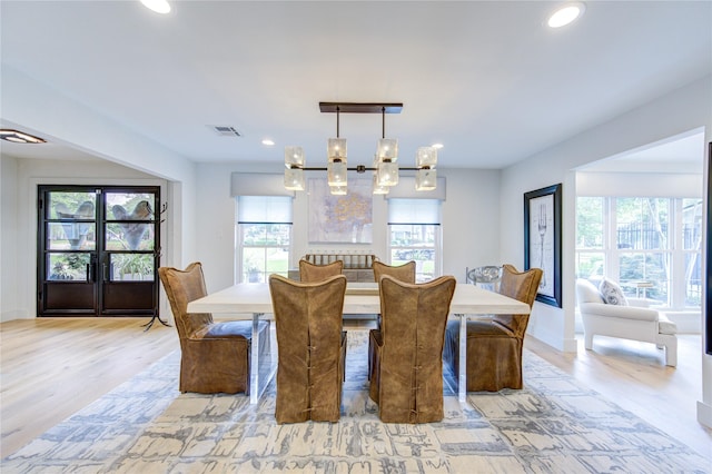 dining room with light hardwood / wood-style flooring and a notable chandelier