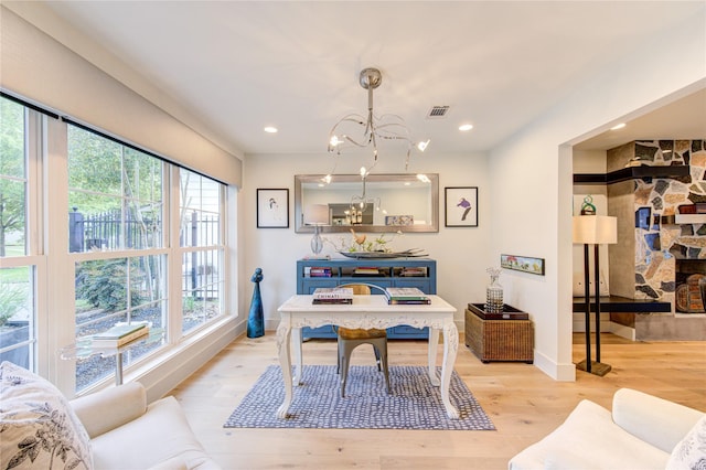 office space with light hardwood / wood-style floors and a notable chandelier