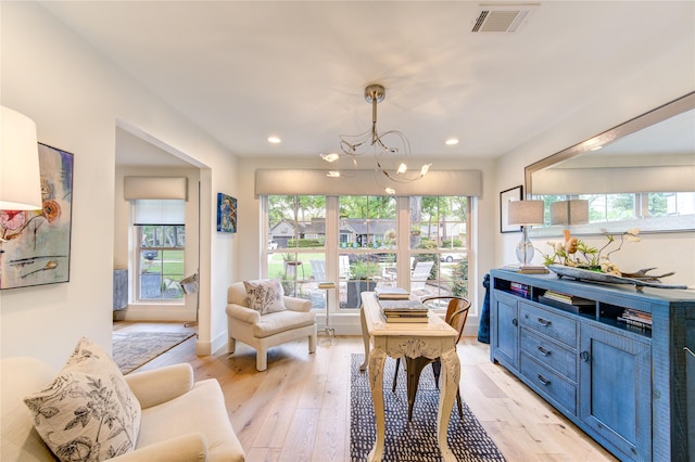 sitting room with light hardwood / wood-style flooring, a wealth of natural light, and a chandelier