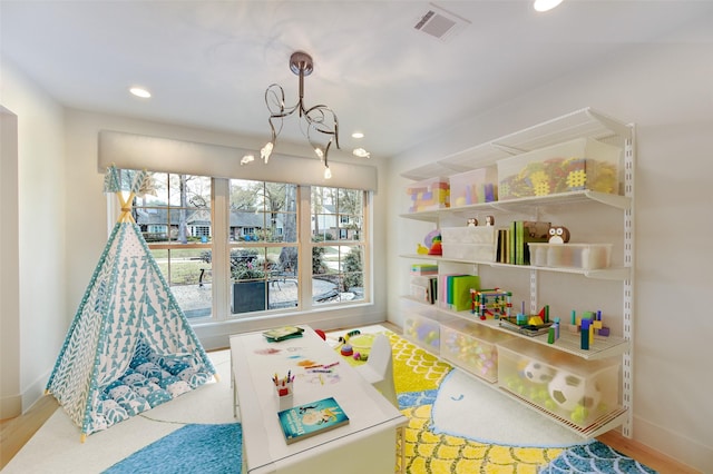 rec room featuring hardwood / wood-style floors and a notable chandelier