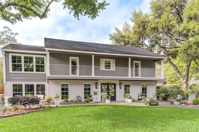 view of front facade with a front lawn and a balcony