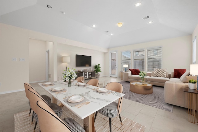 dining area featuring lofted ceiling and light tile patterned floors