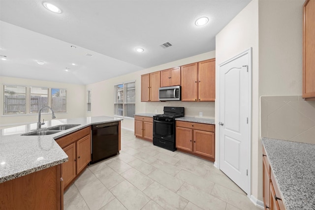 kitchen featuring light stone countertops, sink, lofted ceiling, and black appliances