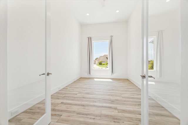 unfurnished room with recessed lighting, french doors, light wood-type flooring, and baseboards