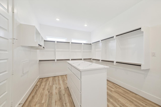 walk in closet with light wood finished floors