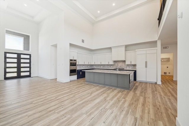 kitchen with visible vents, double oven, white cabinetry, and light countertops