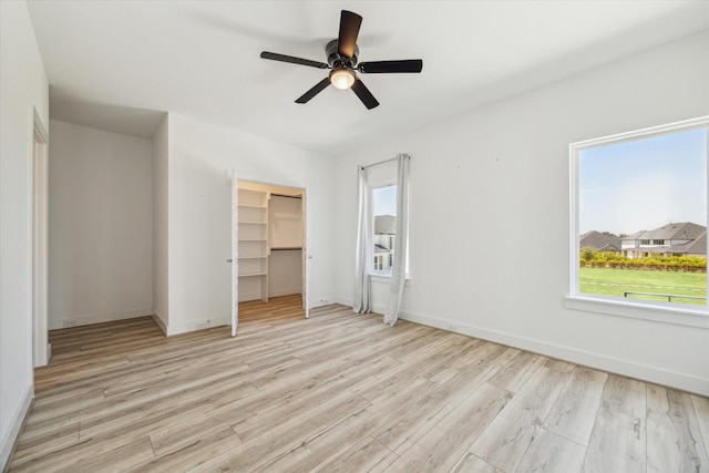 unfurnished bedroom featuring a closet, a ceiling fan, baseboards, and wood finished floors