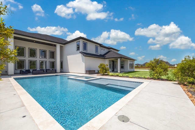 view of pool featuring a patio and a pool with connected hot tub