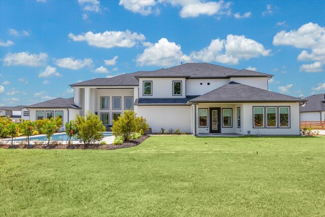 rear view of property featuring a lawn