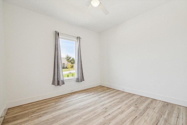 spare room featuring wood finished floors, baseboards, and ceiling fan