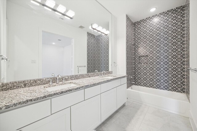 bathroom with tile patterned flooring, double vanity, shower / bathtub combination, and a sink