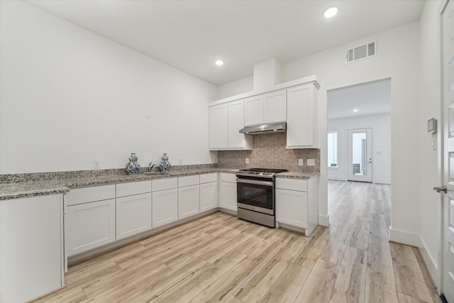 kitchen featuring visible vents, backsplash, light wood-style floors, stainless steel range with gas cooktop, and white cabinets