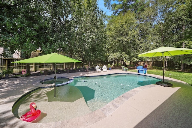 view of pool featuring a patio area, a fenced backyard, and a pool with connected hot tub