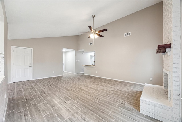 unfurnished living room with a brick fireplace, high vaulted ceiling, and ceiling fan