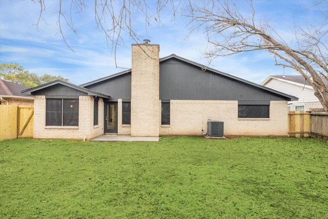 rear view of house with a yard, cooling unit, and a patio area