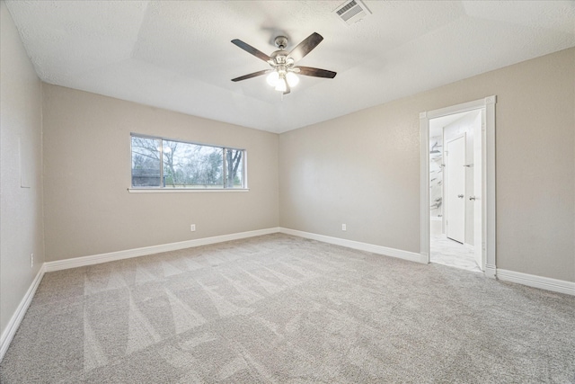 unfurnished room with light colored carpet, a textured ceiling, and ceiling fan