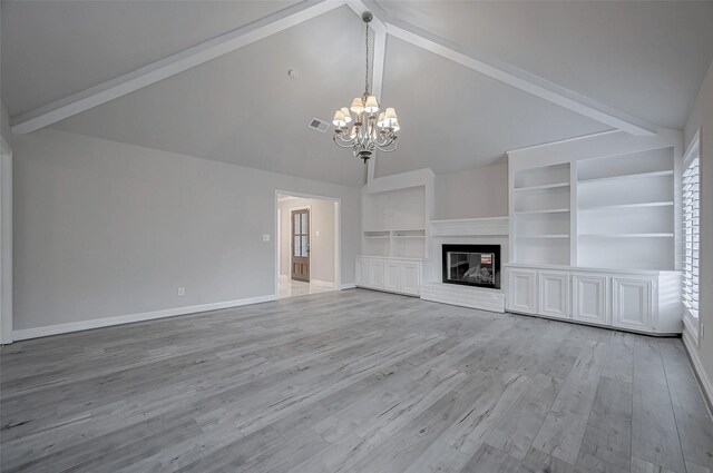 unfurnished living room featuring a brick fireplace, wood-type flooring, lofted ceiling with beams, and a chandelier