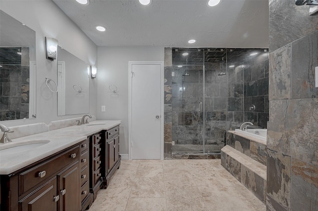 bathroom with independent shower and bath, vanity, and a textured ceiling