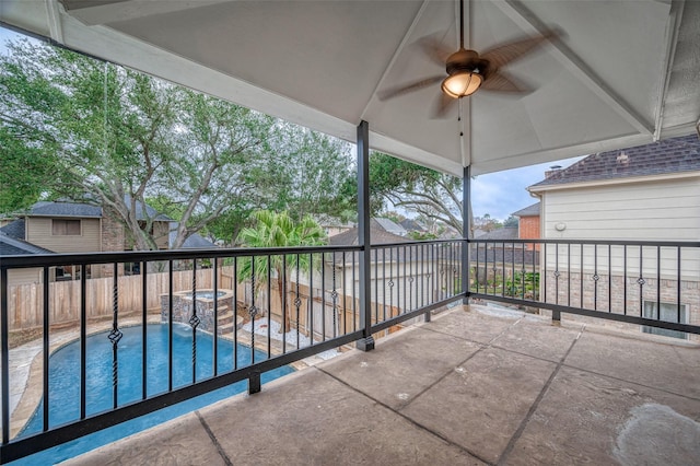 view of patio with a balcony and a swimming pool with hot tub