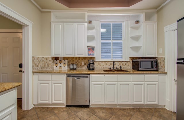 kitchen with sink, appliances with stainless steel finishes, tasteful backsplash, light stone counters, and white cabinets