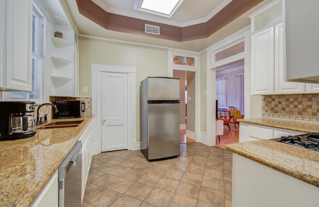 kitchen with white cabinetry, stainless steel appliances, and light stone countertops