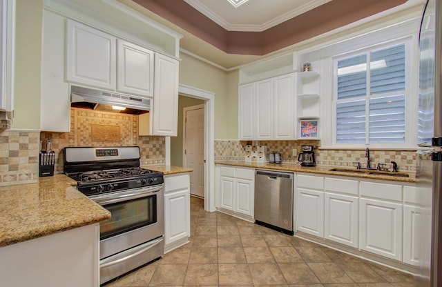 kitchen featuring sink, appliances with stainless steel finishes, light stone countertops, ornamental molding, and white cabinets