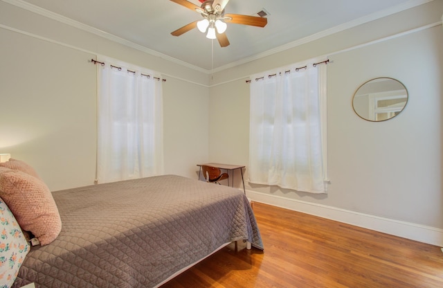 bedroom with hardwood / wood-style flooring, ornamental molding, and ceiling fan